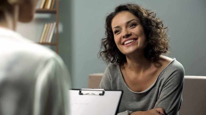 shutterstock_1204439644 Smiling woman talking during a meeting