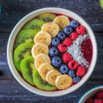 Foods that lead to a better night’s sleep Acai bowl topped with kiwi, banana, blueberries, raspberries, and coconut
