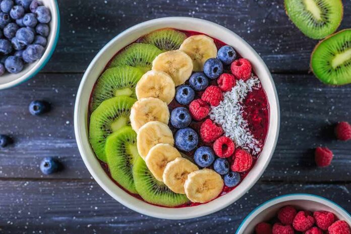 Acai bowl topped with kiwi, banana, blueberries, raspberries, and coconut