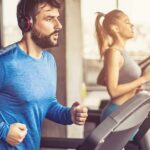 Effect of Mental Fatigue on Workout Performance Man in blue long-sleeve running on a treadmill with headphones