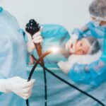 Endometriosis: Chronic Pain, Missing Paychecks Medical staff preparing endoscope near patient on hospital bed