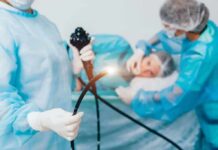 Medical staff preparing endoscope near patient on hospital bed
