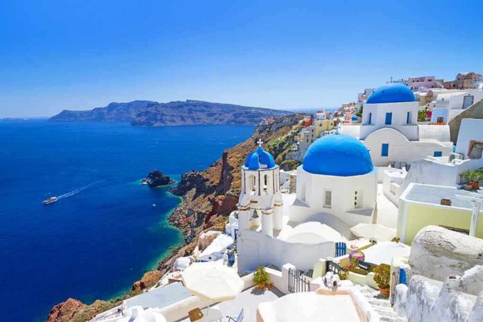 shutterstock_132953783 Scenic view of Santorini with blue domed buildings overlooking the Mediterranean Sea