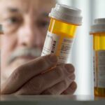 Sleep Apnea Shake-Up: Pill Beats Masks An elderly man holding a prescription bottle while examining it closely