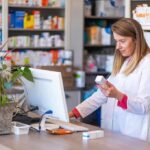 FDA Warning: GLP-1 Microdose Hype Pharmacist checking medication box at computer counter