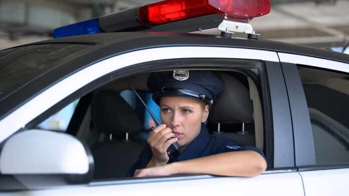 Police officer in patrol car using radio
