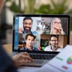 Loneliness Cure — The Tablet Twist Laptop screen showing a four-person video conference call