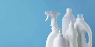 White plastic cleaning bottles against a blue background