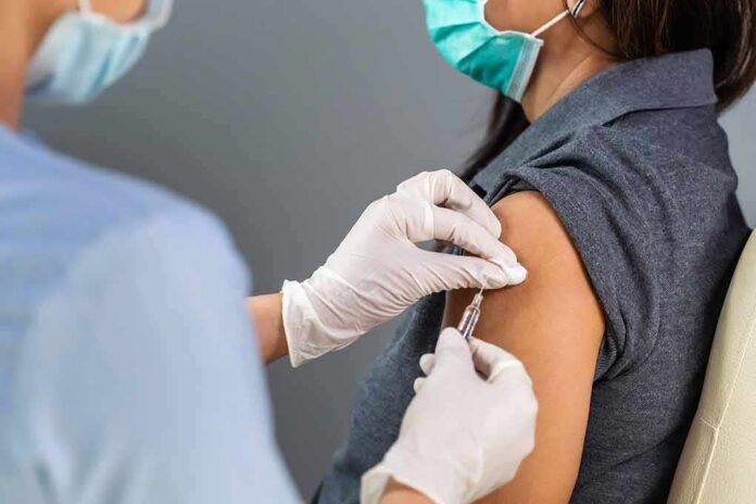 shutterstock_1767084407 Healthcare worker administers vaccine to patient’s upper arm