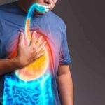 Massive Study Flags ADHD Gut Risks Person clutching chest with illustrated reflux and stomach overlay