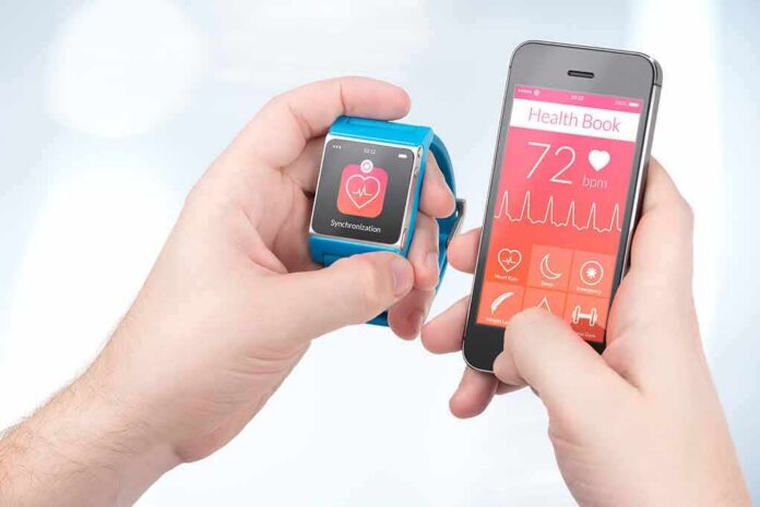 shutterstock_188507768 hands holding a smartwatch and a smartphone with health app