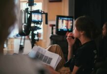 AI Funerals Let The Dead Talk Back film crew member reviewing script beside monitors on set