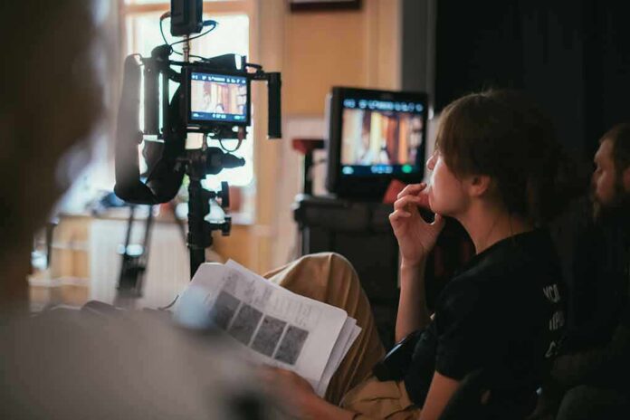 shutterstock_1942991464 film crew member reviewing script beside monitors on set