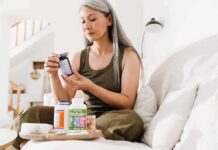 Harvard Slams Antioxidant Pills Woman reading supplement bottle label on a sofa
