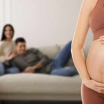 Baby Market Boom | Why the world wants American surrogates Pregnant woman holding her belly in a living room