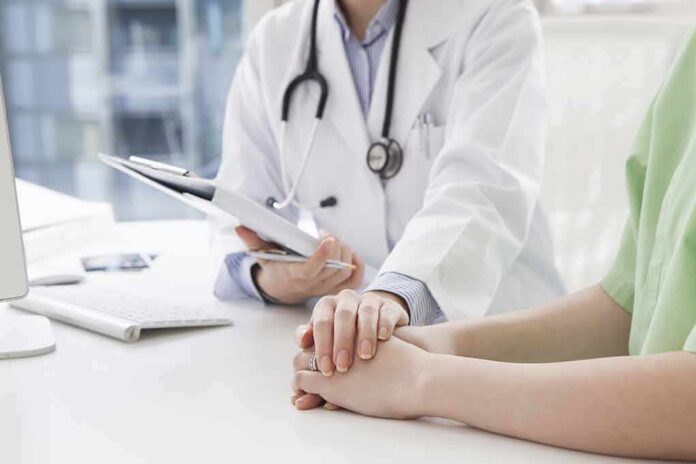 shutterstock_266789537-1 Doctor holding a patient's hands during consultation