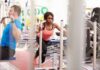 Scientists End Pre-Workout Coffee Debate Woman lunging on sled in gym next to man using cable machine