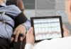 Technician reviews polygraph readings on a tablet beside a seated subject