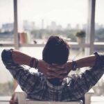Person relaxing in chair facing large window