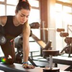 Gym Rookie Mistakes Quietly Wrecking Your Gains Woman performing dumbbell row in a gym