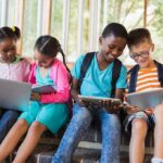 Popcorn Brains – Doomscrolling’s Impact Children using laptops and tablets on school steps