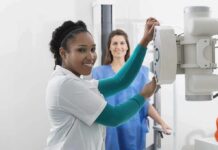 Spotify Billionaire’s Full-body Scan Sparks Medical Backlash Radiologic technologist adjusting X-ray machine with patient standing behind