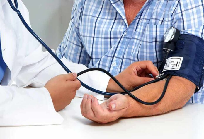 Patient getting blood pressure checked with a cuff and stethoscope