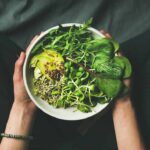 Fibermaxxing: Gut Health Miracle or Dangerous Gamble? hands holding a bowl of fresh green salad