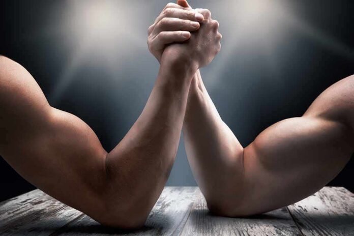 shutterstock_668312992 Two muscular arms locked in an arm wrestling match