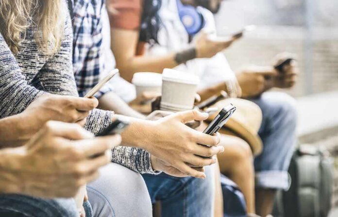 shutterstock_794117806 Group of people sitting and using smartphones