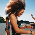 Young woman dancing on a sunny beach