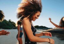 Young woman dancing on a sunny beach