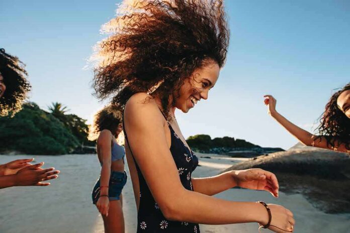 Young woman dancing on a sunny beach