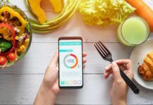 How To Keep Hitting Your Protein Goals When Appetite Disappears hands holding phone with calorie tracker beside salad and pastry