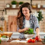 Woman preparing a fresh salad in a home kitchen