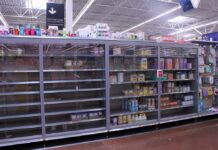 Partially empty store shelves with baby formula and supplies