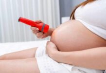 Fish Habit Tied To Dangerous Pregnancy Risk Pregnant woman shining flashlight on bare belly