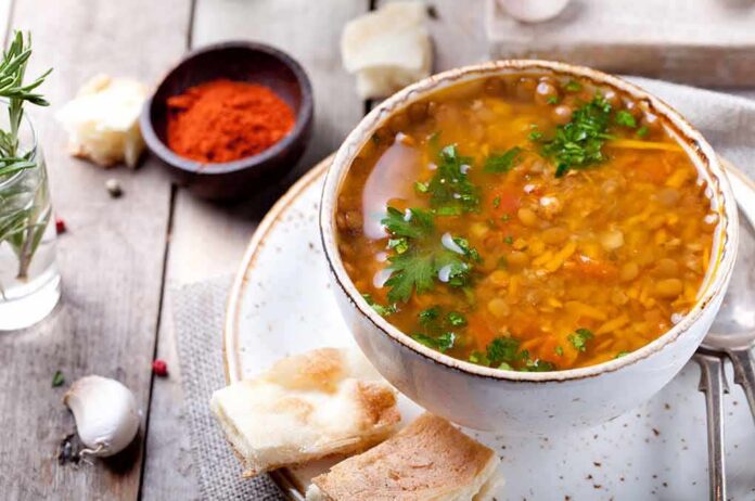 shutterstock_216995815 Bowl of lentil soup with herbs on rustic table