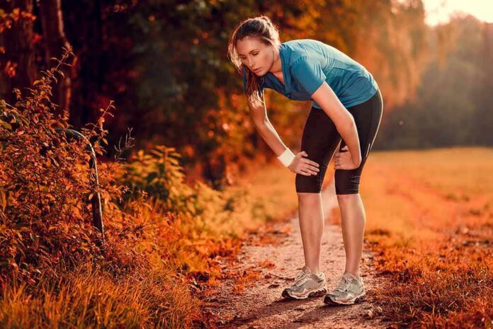 Runner resting on a forest trail in autumn