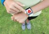 Wearables That Whisper Before Disaster Person checking smartwatch heart rate on wrist outdoors