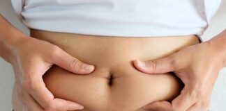person pinching belly fat at the waist