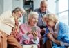 Group of seniors smiling and looking at a smartphone together