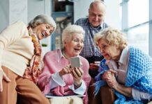 Group of seniors smiling and looking at a smartphone together